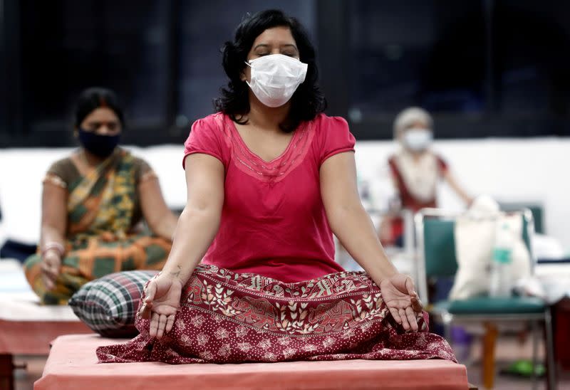 FILE PHOTO: People suffering from the coronavirus disease (COVID-19) perform yoga inside a care centre for COVID-19 patients at an indoor sports complex in New Delhi