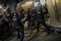 Police clash with protesters during a demonstration at El Prat airport, outskirts of Barcelona, Spain, Monday, Oct. 14, 2019. Spain's Supreme Court on Monday sentenced 12 prominent former Catalan politicians and activists to lengthly prison terms for their roles in a 2017 bid to gain Catalonia's independence, sparking protests across the wealthy Spanish region. (AP Photo/Bernat Armangue)