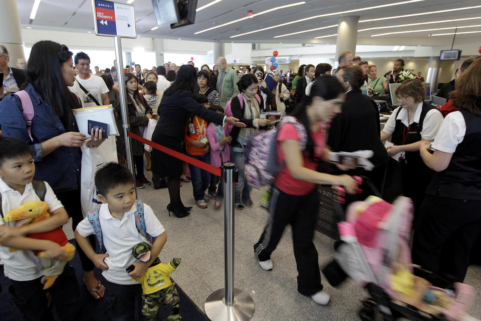 Passengers board a plane to Tokyo, the first flight to leave out of the the new Maynard Holbrook Jackson Jr. International Terminal at Atlanta's airport on the first day it begins operating flights Wednesday, May 16, 2012, in Atlanta. (AP Photo/David Goldman)