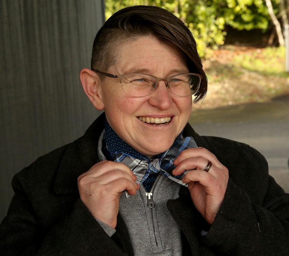 Dana Coggon puts on one of her signature bow ties before a quick walk to the Madrona Trails in Bremerton on Thursday.