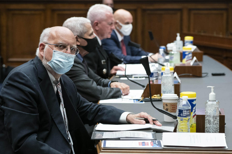 FILE - In this Tuesday, June 23, 2020 file photo, Dr. Robert Redfield, director of the Centers for Disease Control and Prevention, left, listens during a House Committee on Energy and Commerce on the Trump administration's response to the COVID-19 pandemic on Capitol Hill in Washington. On Friday, July 17, 2020, The Associated Press reported on a photo circulating online incorrectly asserting it shows a CDC report with many claims about face masks, including that cloth masks trap exhaled carbon dioxide and collect mildew within 30 minutes, risking your health. The document in the photo is fake and falsely attributed to the CDC, the agency told The Associated Press. (Sarah Silbiger/Pool via AP)