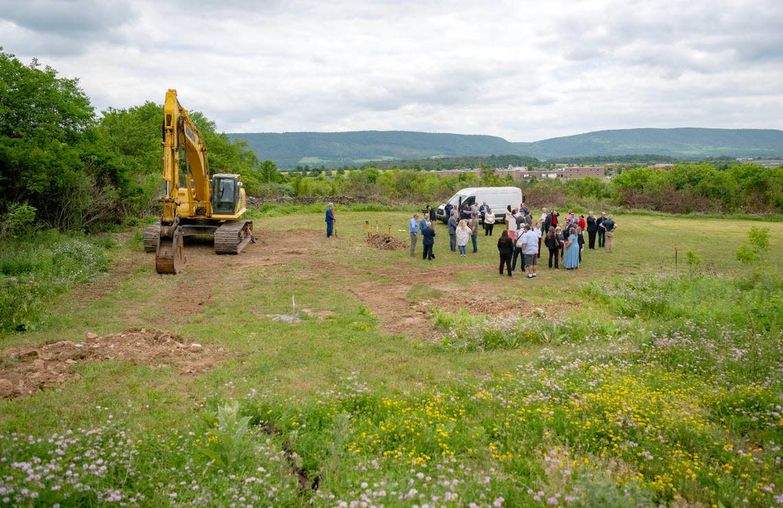 People mingle at the site of the Tru Hotel by Hilton that will be built along Benner Pike on Tuesday, June 11, 2024.