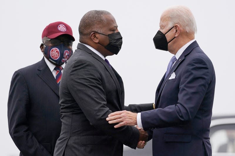 President Joe Biden is greeted by Columbia Mayor Steve Benjamin and Rep. Jim Clyburn, D-S.C., left, as he arrives at Columbia Metropolitan Airport on Air Force One in West Columbia, S.C., Dec. 17, 2021.