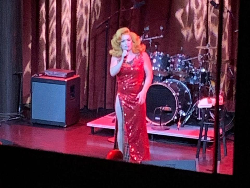 a prformer in a red dress on stage