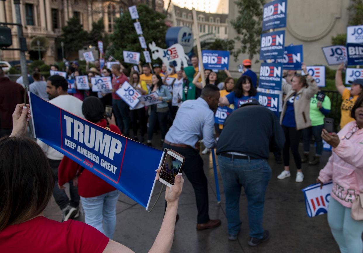 A supporter of Mr Trump with a placard outside the venue of the Democratic debate: Getty