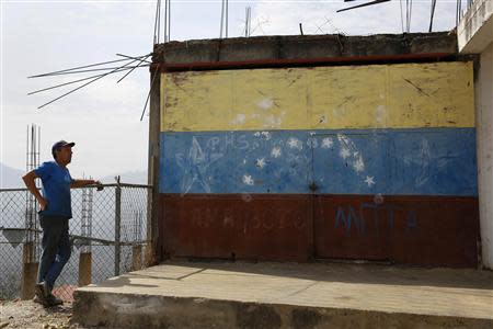 Auto mechanic Juan Freire stands next to the headquaters of El Chaparral neighbourhood in La Guaira May 2, 2014. REUTERS/Carlos Garcia Rawlins