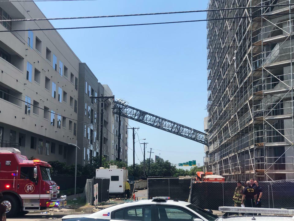 This photo taken and provided by Michael Santana shows a construction crane toppling on an apartment building as it was buffeted by high winds during a storm in Dallas, Texas, Sunday, June 9, 2019. (Michael Santana via AP)