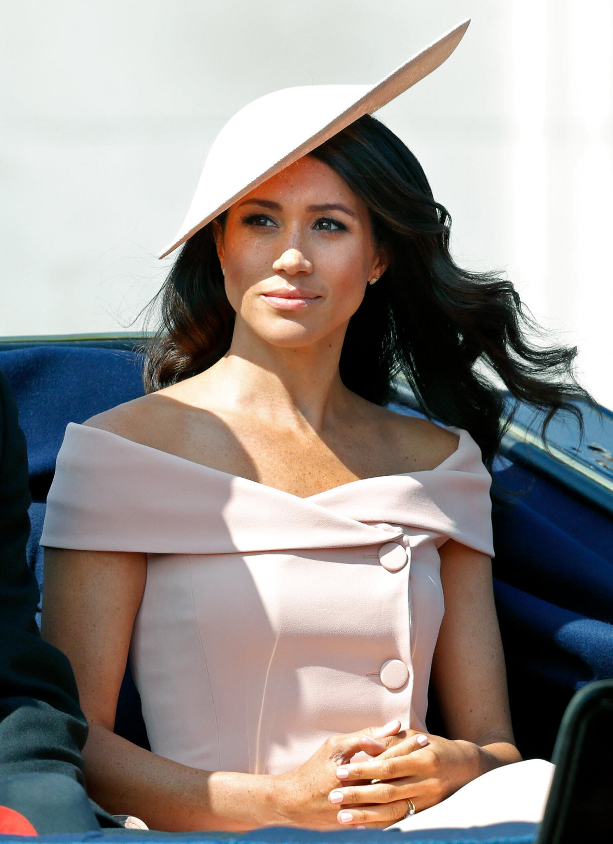 Meghan Markle crosses her hands and looks solemn in a pink dress and hat at the Tropping of the Colour