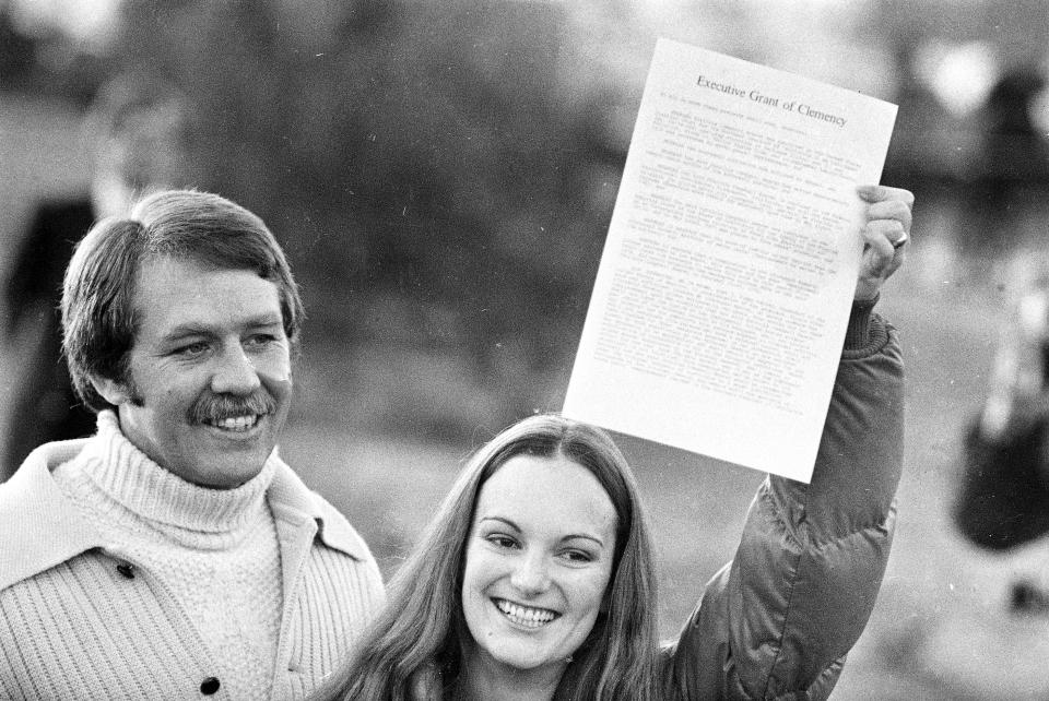 FILE - A happy Patricia “Patty” Hearst displays the executive grant of clemency as she leaves the Federal Correctional Institution in Pleasanton, Calif., Feb. 2, 1979. With her is fiance Bernard Shaw, her former bodyguard. The newspaper heiress was kidnapped at gunpoint 50 years ago Sunday, Feb. 4, 2024, by the Symbionese Liberation Army, a little-known armed revolutionary group. The 19-year-old college student's infamous abduction in Berkeley, Calif., led to Hearst joining forces with her captors for a 1974 bank robbery that earned her a prison sentence. Hearst, granddaughter of wealthy newspaper magnate William Randolph Hearst, will turn 70 on Feb. 20. (AP Photo/File)
