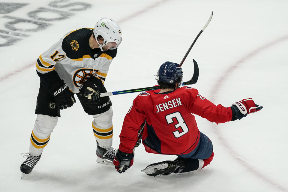 Boston Bruins right wing Craig Smith (12) and Washington Capitals defenseman Nick Jensen (3) get tangled up during the second period of Game 2 of an NHL hockey Stanley Cup first-round playoff series Monday, May 17, 2021, in Washington. (AP Photo/Alex Brandon)