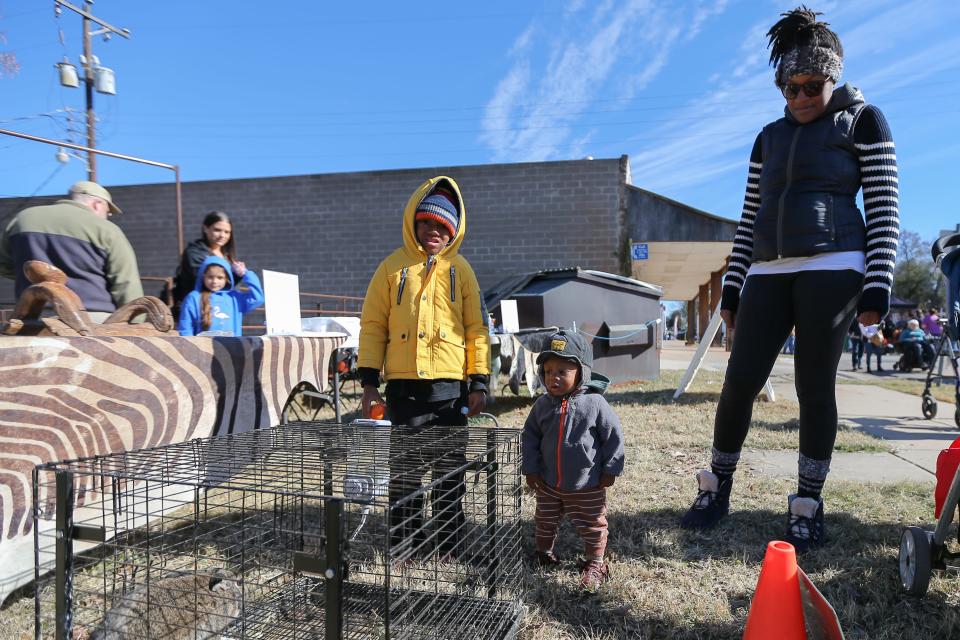 Gabriel and Jonathan Parker look at a bunny with their mother Camille Parker at The Luther Pecan Festival in Luther on Saturday, Nov. 19, 2022.