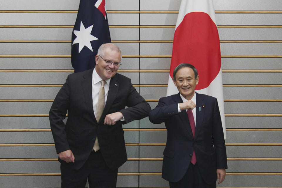 Australian Prime Minister Scott Morrison, left, poses with Japanese Prime Minister Yoshihide Suga at the start of their meeting at Suga's official residence in Tokyo Tuesday, Nov. 17, 2020. Morrison is in Japan to hold talks with his Japanese counterpart, Yoshihide Suga, to bolster defense ties between the two U.S. allies to counter China’s growing assertiveness in the Asia-Pacific region. (AP Photo/Eugene Hoshiko, Pool)