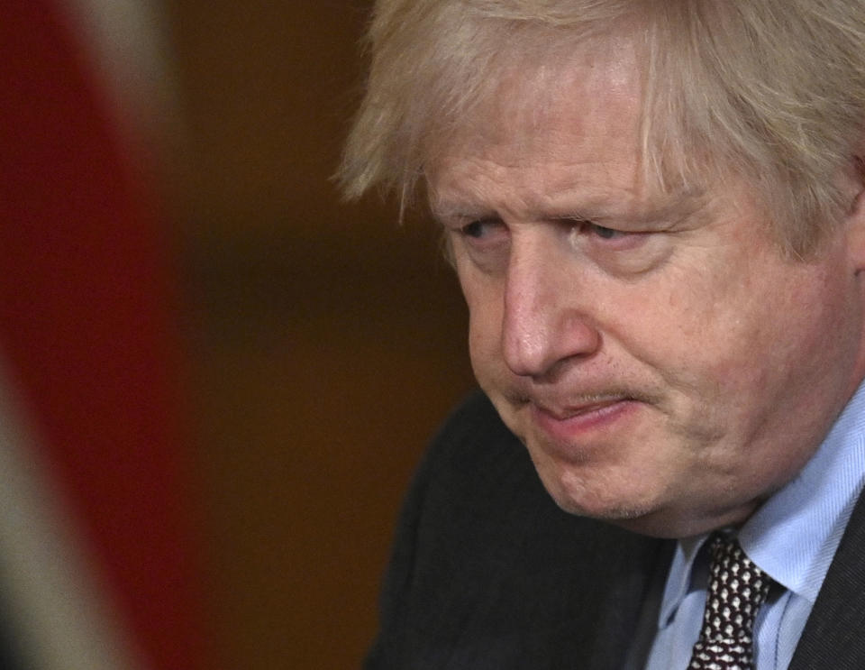 Britain's Prime Minister Boris Johnson leaves the podium after leading a virtual press conference on the Covid-19 pandemic, inside 10 Downing Street in central London Tuesday Jan. 26, 2021. Official data shows that more than 100,000 people have died after testing positive for coronavirus in Britain, since the pandemic took hold last year. (Photo by JUSTIN TALLIS / POOL / AFP)