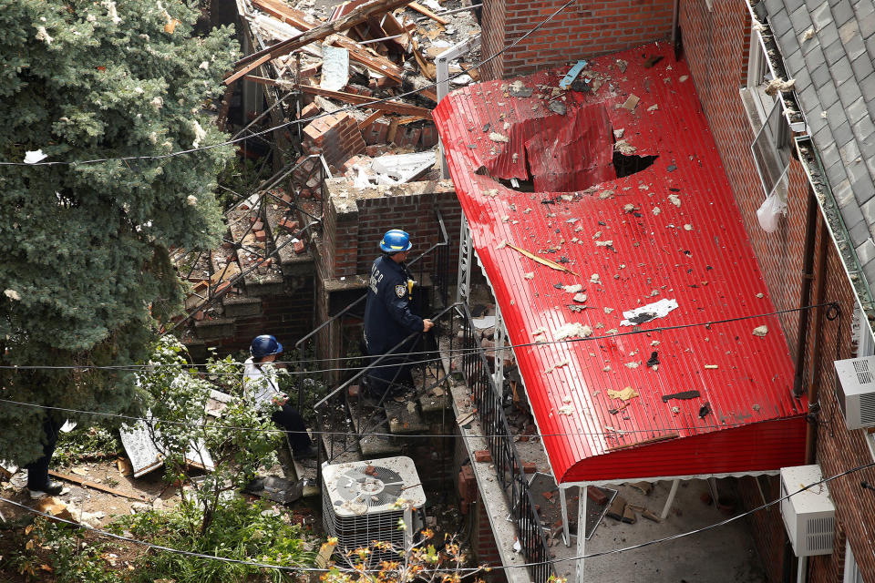 <p>Officials walk into the home next door of a home that was destroyed by an explosion in the early morning in the Bronx borough of New York on Sept. 27, 2016. (Carlo Allegri/Reuters) </p>
