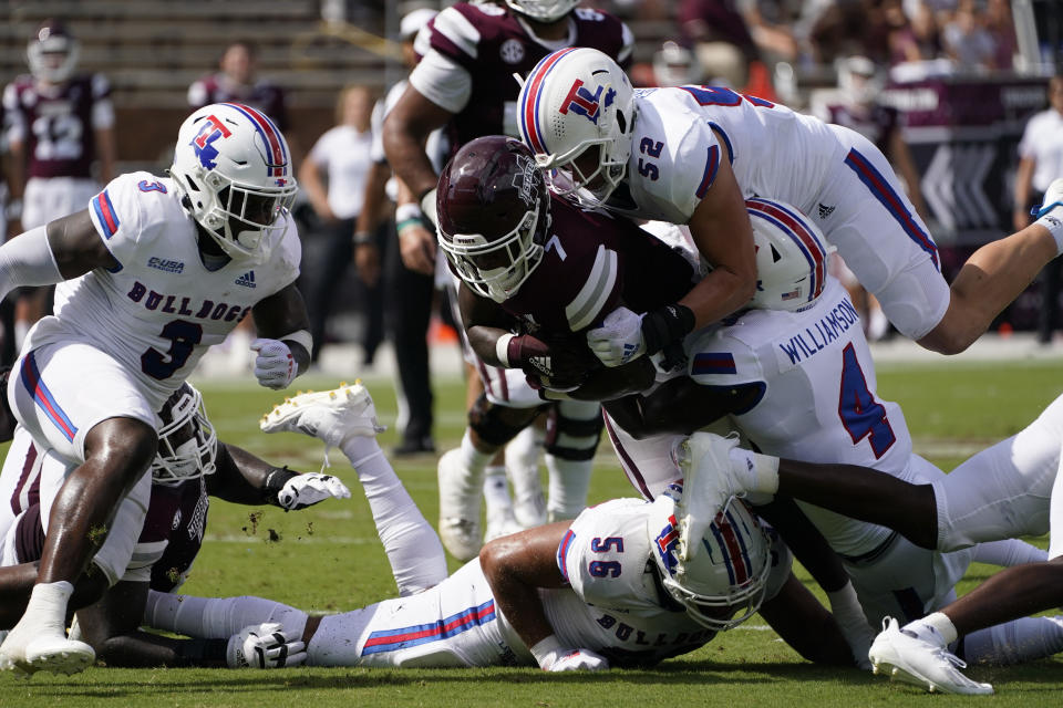 Mississippi State running back Jo'quavious Marks (7) is gang tackled by Louisiana Tech defenders, including linebacker Tyler Grubbs (52) and defensive back BeeJay Williamson (4) during the first half of an NCAA college football game in Starkville, Miss., Saturday, Sept. 4, 2021. (AP Photo/Rogelio V. Solis)