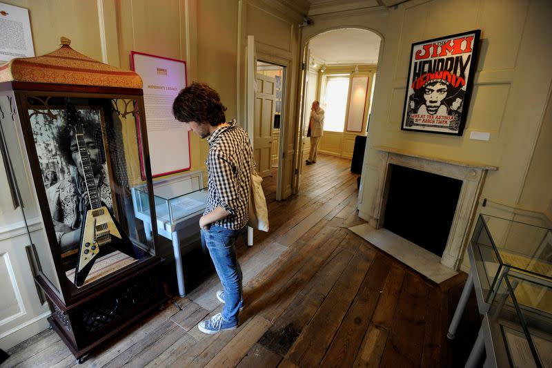 FILE PHOTO: A man poses for photographers as he looks at items which belonged to Jimi Hendrix, during an exhibition to mark the 40th anniversary of his death