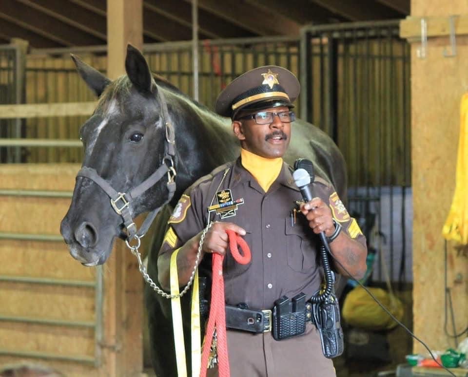 Sgt. Lee Eric Smith with his mount, Doc, talking to children at the Detroit Horsepower Kids Camp in an undated photo. Smith rode Doc for the Wayne County Sheriff's Office Mounted Division for 11 years. Smith died in August 2018 and Doc died in September 2021. Doc's remains will be interred at the Michigan War Dog Memorial cemetery in Lyon Township.