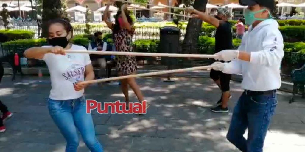 Practican pasos de baile con sana distancia en el zócalo de Puebla