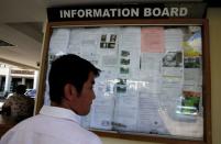 A man stands in front of an information board featuring people seeking jobs and rental houses at Kemang district in Jakarta, Indonesia, June 22, 2016. Picture taken June 22, 2016. REUTERS/Beawiharta
