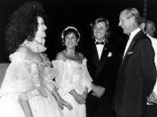 <p>An amused Duke of Edinburgh, patron of Elizabethan-themed Berkeley Square Ball, London, with actress Cleo Rocos (left) and dress designers Elizabeth and David Emmanuel, who made the wedding dress for the Princess of Wales. They donated a dress for auction and boxer Henry Cooper (far right) acted as one of the auctioneers. </p>