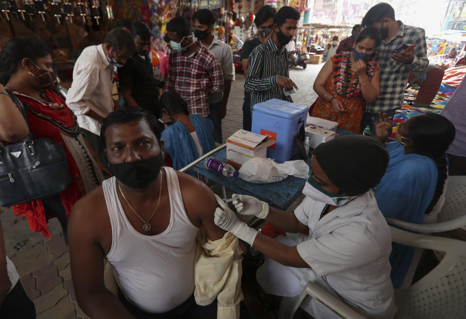A health worker administers the Covishield vaccine for COVID-19 at a temple premise in Hyderabad, India, Wednesday, Jan. 12, 2022. (AP Photo/Mahesh Kumar A.)