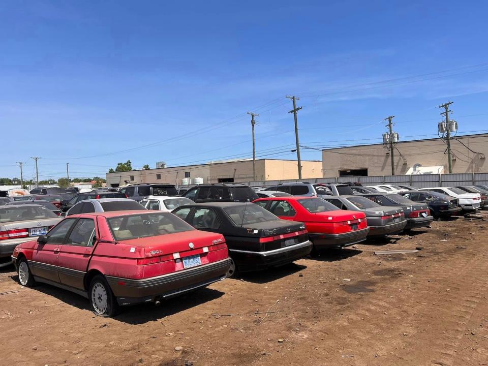 A series of historic Alfa Romeos in a junkyard