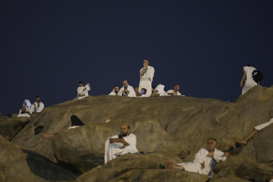 Muslim pilgrims gather at top of the rocky hill known as the Mountain of Mercy, on the Plain of Arafat, during the annual Hajj pilgrimage, near the holy city of Mecca, Saudi Arabia, Saturday, June 15, 2024. Masses of Muslims gathered at the sacred hill of Mount Arafat in Saudi Arabia for worship and reflection on the second day of the Hajj pilgrimage. The ritual at Mount Arafat, known as the hill of mercy, is considered the peak of the Hajj. It's often the most memorable event for pilgrims, who stand shoulder to shoulder, asking God for mercy, blessings, prosperity and good health. Hajj is one of the largest religious gatherings on earth.(AP Photo/Rafiq Maqbool)