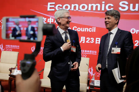 Apple CEO Tim Cook and BMW's Chairman of the Board of Management Harald Krueger attend the China Development Forum in Beijing, China March 23, 2019. REUTERS/Thomas Peter