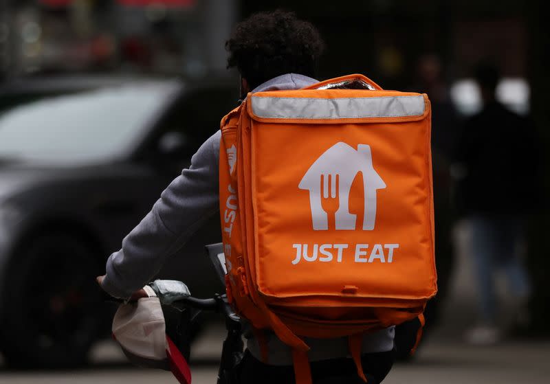 A Just Eat delivery rider cycles through Manchester