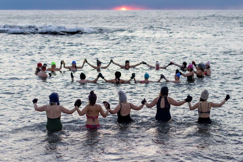 Women bathe in the chilly waters of Lake Ontario during freezing temperatures in Toronto