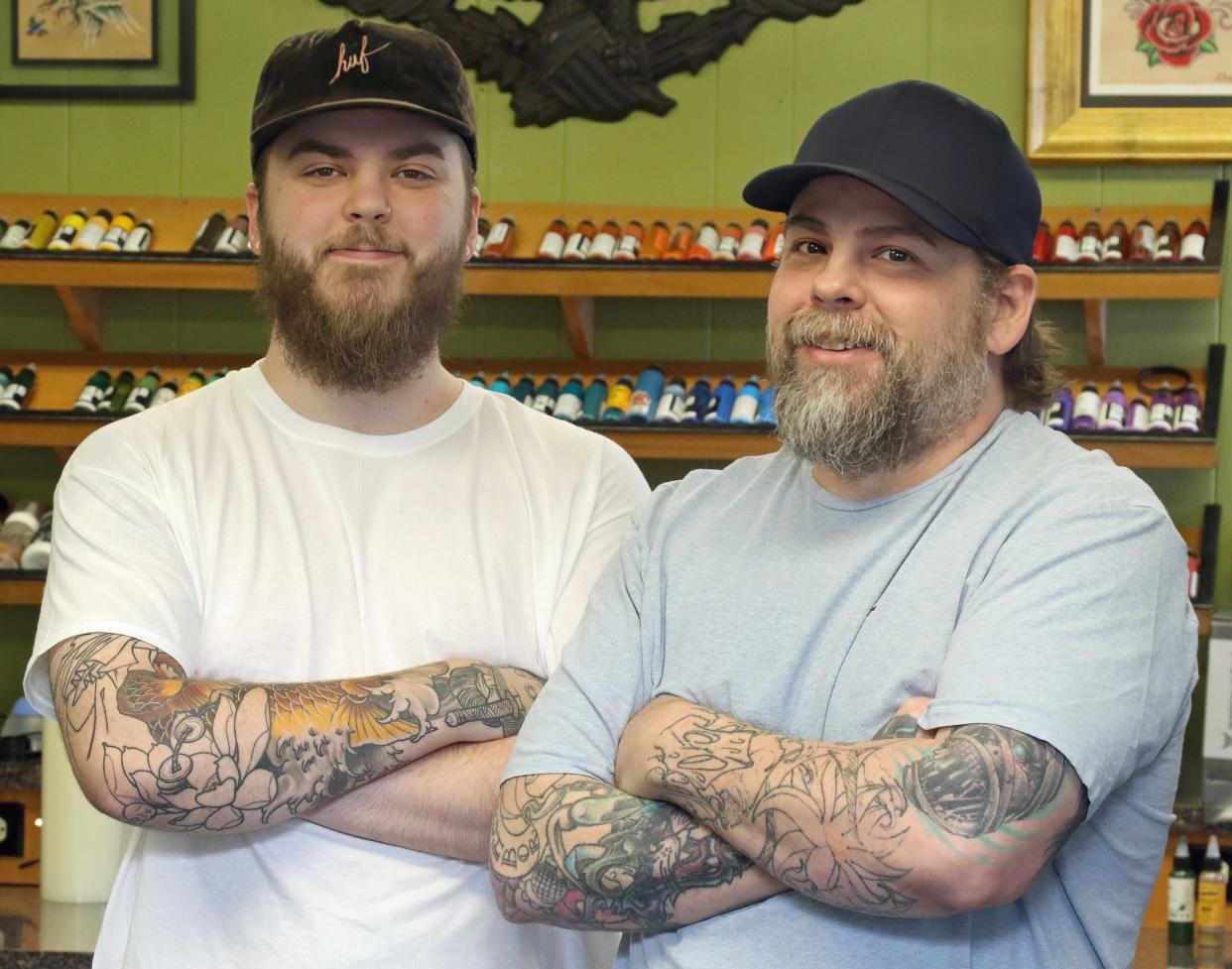 Owners Tevin Greene and his dad, Lee Greene, pose together Thursday afternoon, April 18, 2024, inside Greeneworks Tattoo in Shelby.