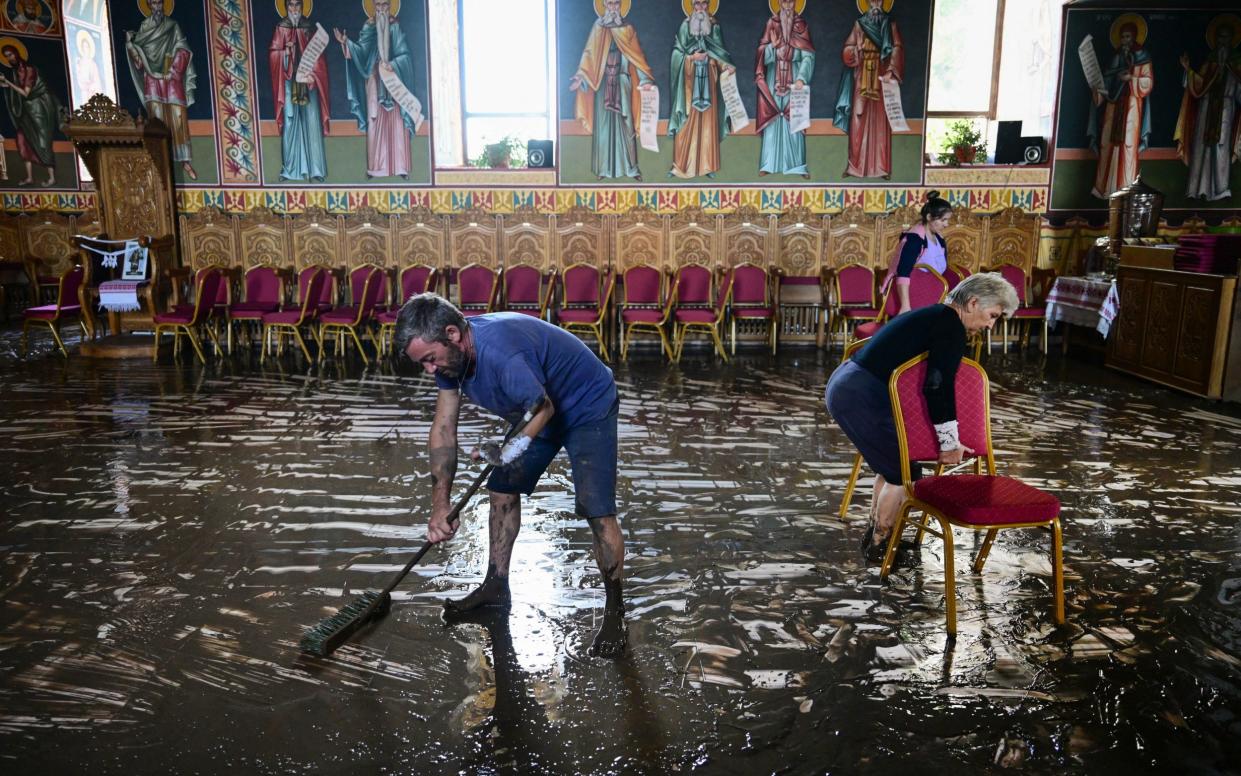 The clean-up operation begins in a church after flooding receded in Pechea, Romania