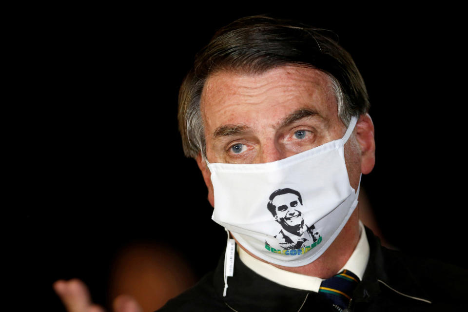 Image: Brazil's President Jair Bolsonaro speaks with journalists while wearing a protective face mask as he arrives at Alvorada Palace (Adriano Machado / Reuters file)