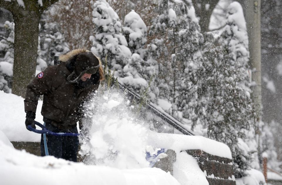 A man shovels snow during a snow storm in Toronto, December 14, 2013. Approximately 15 to 20 cm of snow may fall by Sunday morning for areas near the Lakeshore in Toronto and Mississauga, according to weather forecaster Environment Canada. REUTERS/Aaron Harris (CANADA - Tags: ENVIRONMENT SOCIETY)