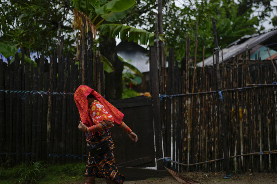 Una mujer indígena Guna se cubre la cabeza debido a una lluvia ligera en la isla Gardí Sugdub, parte del archipiélago de San Blas frente a la costa caribeña de Panamá, el sábado 25 de mayo de 2024. Debido al aumento del nivel del mar, unas 300 familias indígenas Guna se trasladarán a nuevos hogares, construidos por el gobierno, en tierra continental. (Foto AP/Matías Delacroix)