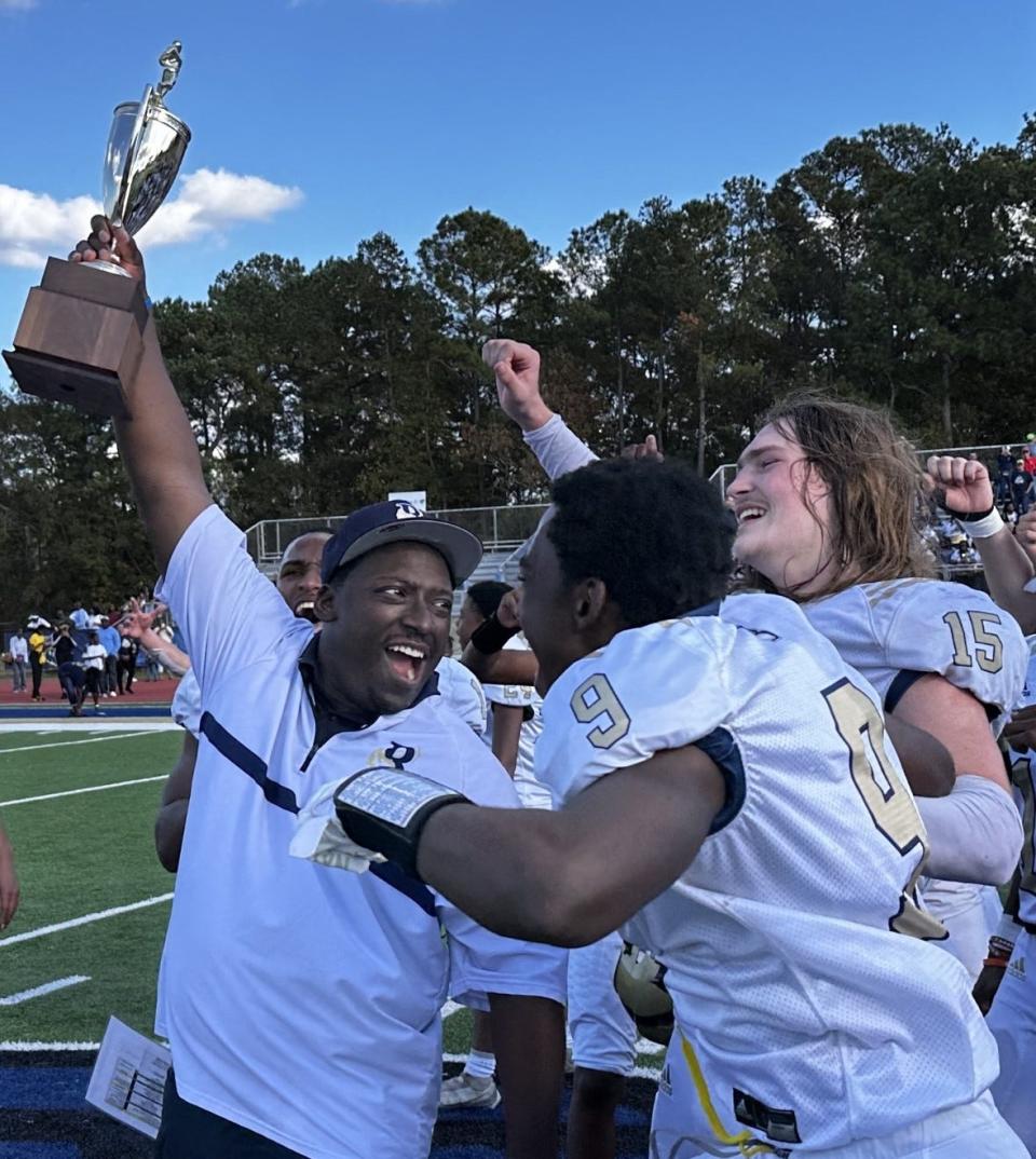 Bethesda coach Antwain Turner celebrates winning the SCISA state football title with his son, Jadon, No. 9, and Triston Randall.