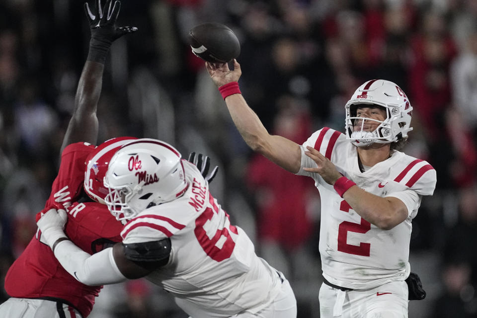 Mississippi quarterback Jaxson Dart (2) throws as offensive lineman Quincy McGee (67) blocks Georgia defensive lineman Tramel Walthour (90) during the first half of an NCAA college football game, Saturday, Nov. 11, 2023, in Athens, Ga. (AP Photo/John Bazemore)