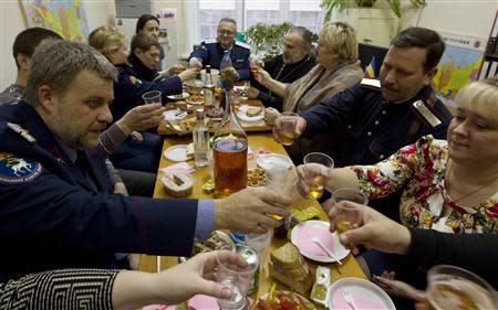 Russian Cossacks and their wives sit at a table during Orthodox Christmas celebrations in the southern Russian city of Volgograd, January 7, 2014. REUTERS/Vasily Fedosenko