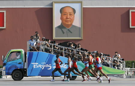 Competitors run in front of the Tiananmen Gate with the portrait of Chairman Mao during the men's marathon at the Beijing 2008 Olympic Games, August 24, 2008. REUTERS/Alfred Cheng Jin/File Photo