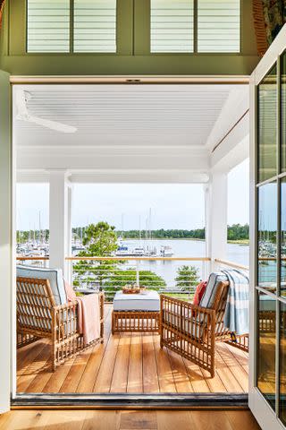 PHOTOGRAPHY BY LAUREY W. GLENN; STYLING BY KENDRA SURFACE Marvin French doors open from the primary bedroom onto the upstairs porch. Lounge chairs offer spots to settle in for the sunset.