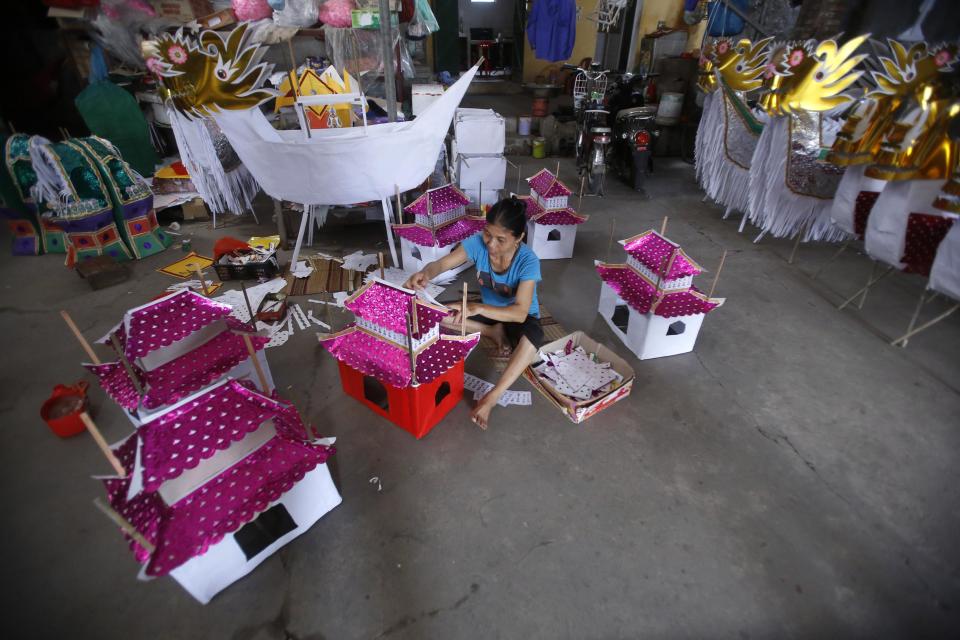 A woman makes paper replicas of houses to be sold for the Vu Lan Festival at Dong Ho village, outside Hanoi