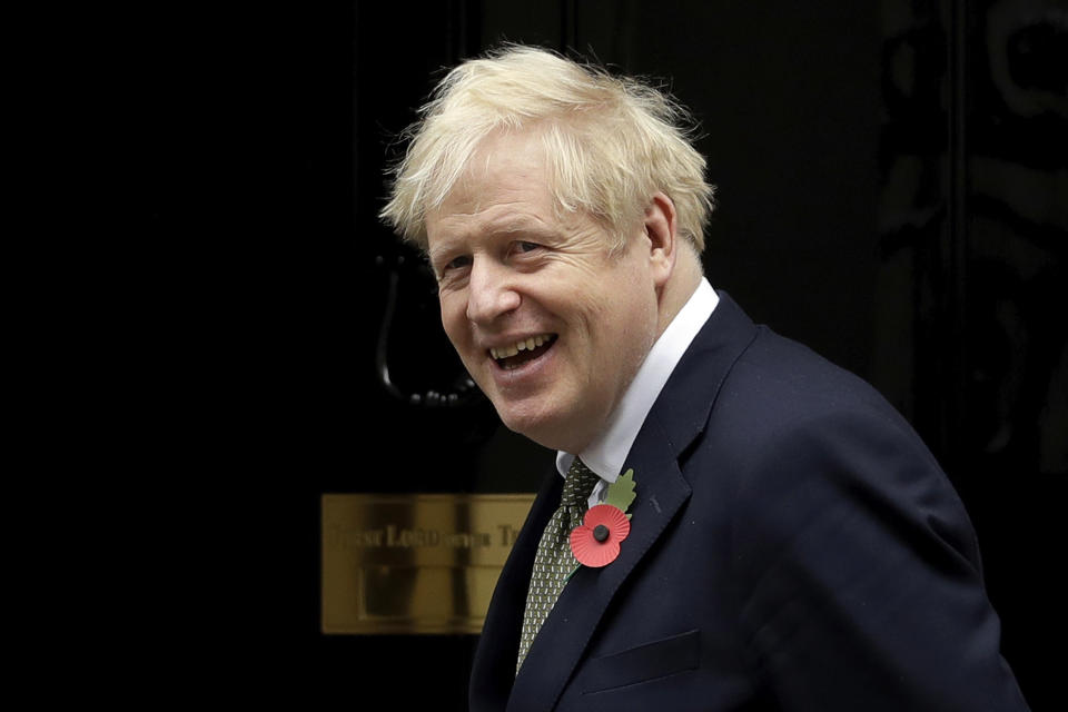 FILE - In this Friday, Oct. 23, 2020 file photo, British Prime Minister Boris Johnson turns to walk back inside as he finishes posing for photographs with members of the British military to mark the launch of the annual Royal British Legion Poppy appeal outside 10 Downing Street, in London. Pediatricians are urging the British government to reverse course and provide free meals for poor children during school holidays as the COVID-19 pandemic pushes more families into poverty. (AP Photo/Matt Dunham, File)