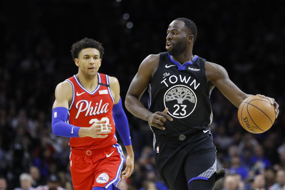 Golden State Warriors' Draymond Green, right, dribbles past Philadelphia 76ers' Matisse Thybulle during the first half of an NBA basketball game Tuesday, Jan. 28, 2020, in Philadelphia. (AP Photo/Matt Slocum)