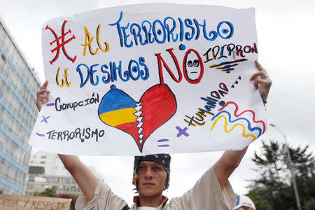 A man holding a placard that reads, "To the terrorism, we say no", as he takes part in a rally against violence, following a car bomb explosion, in Bogota, Colombia January 20, 2019. REUTERS/Luisa Gonzalez