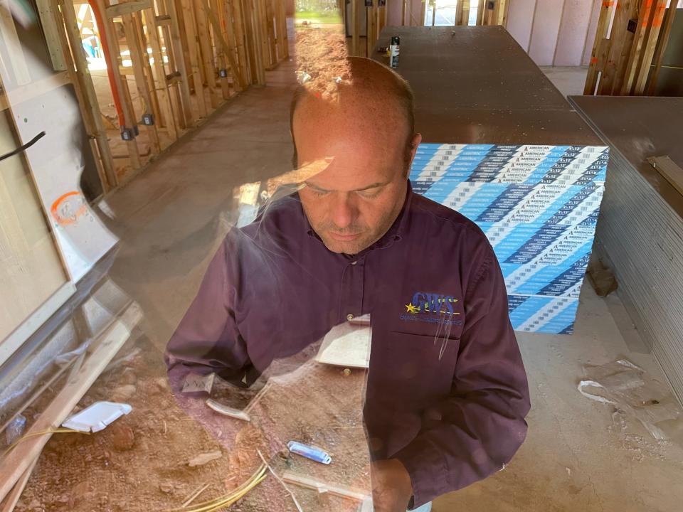 Matt Risinger, residential home inspector for Guaranteed Watt Saver, is seen through a window during an interim energy inspection Friday of a home in Valencia addition in northwest Oklahoma City.