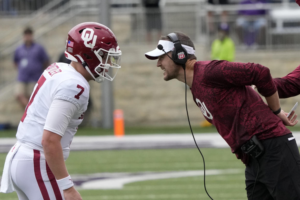 Oklahoma head coach Lincoln Riley, right, talks with quarterback Spencer Rattler (7) during the first half of an NCAA college football game against Kansas State in Manhattan, Kan., Saturday, Oct. 2 2021. (AP Photo/Orlin Wagner)