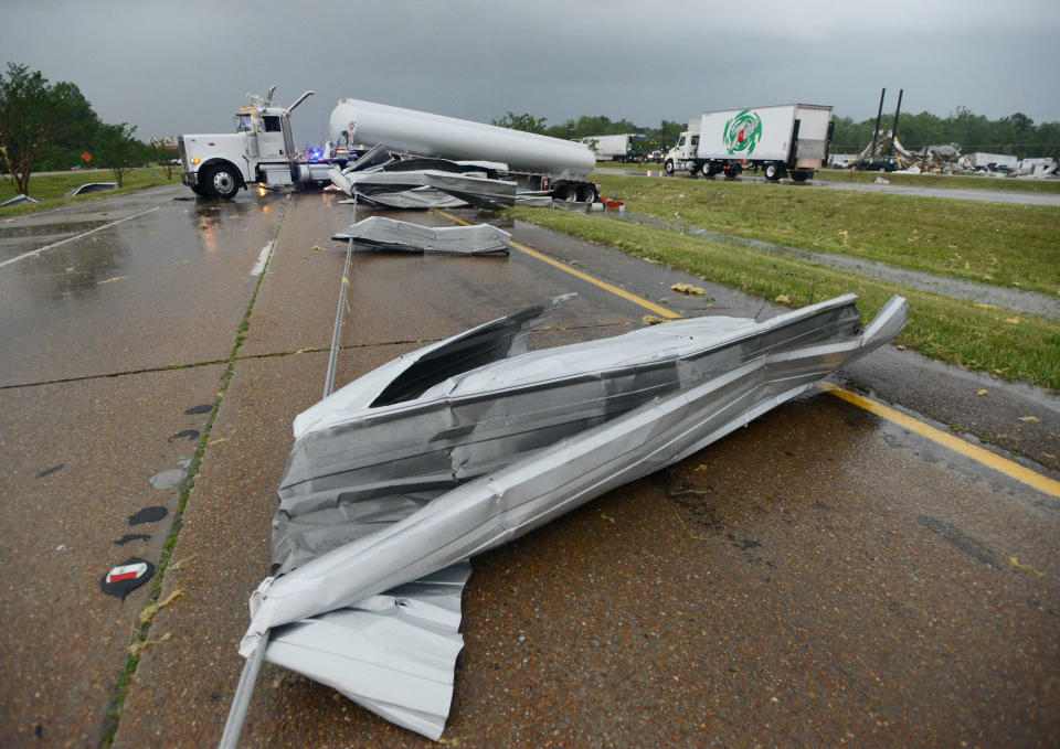An 18-wheeler and numerous strips of sheet metal block the southbound lanes of U.S. 49 in Richland, Miss., after a tornado ripped through the area late Monday afternoon, April 28, 2014. According to the truck's driver, he was alerted to the tornado in time to pull to the shoulder, lock his brakes and curl into the floor of his cab before the rig was spun 90 degrees amid a hail-storm of flying debris when the tornado passed. The driver was unhurt. (AP Photo/The Clarion-Ledger, Joe Ellis) NO SALES