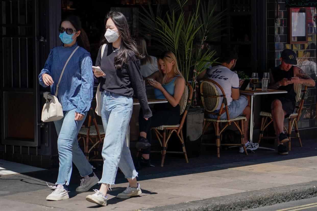 People sit at outdoor tables at a restaurant in Soho, in London, on Monday as coronavirus cases hit the highest daily rate since February. (AP)