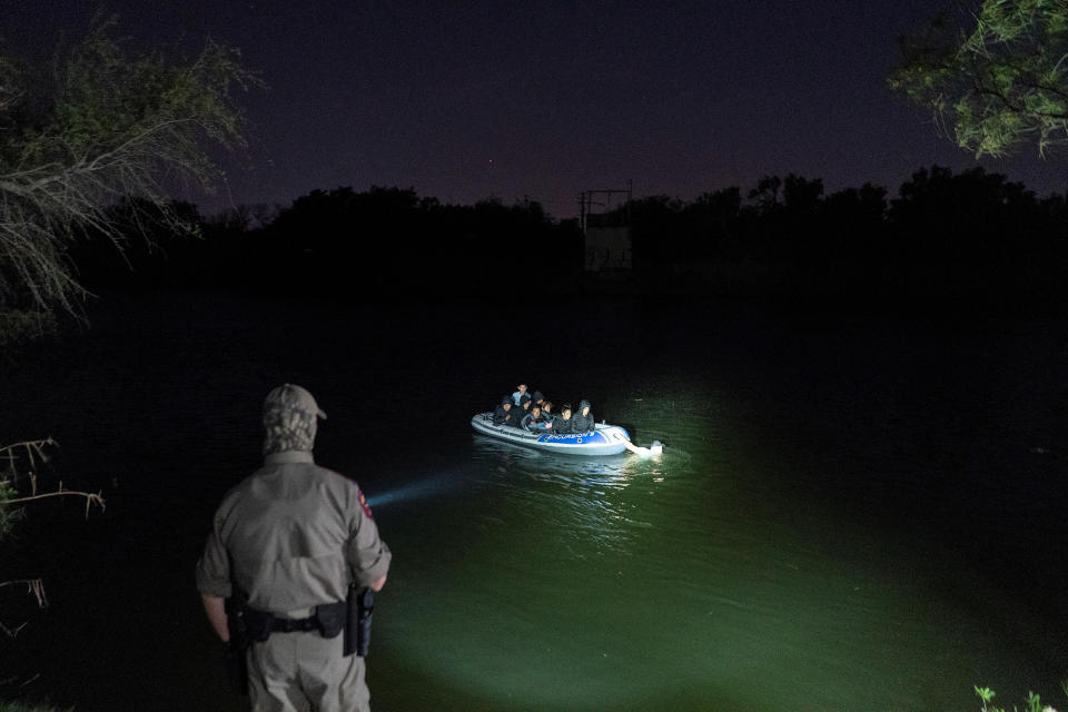 Asylum-seeking migrants' families cross the Rio Grande from Mexico as a Texas State Trooper officer points a flashlight at the inflatable raft in Roma, Texas, on April 8, 2021. The raft later turned back to the Mexican side and did not land on the U.S. side of the river.<span class="copyright">Go Nakamura—Reuters</span>