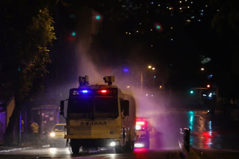 A water cannon of the Bolivarian national riot police sprays disinfectant during the national quarantine in response to the spread of coronavirus disease (COVID-19) in Caracas
